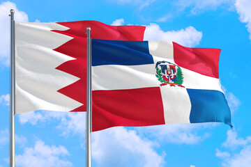 Dominican Republic and Bahrain national flag waving in the windy deep blue sky. Diplomacy and international relations concept.