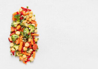 Frozen vegetables mix on a white background. Sliced frozen vegetable salad. View from above. Copy...