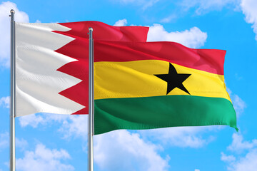 Ghana and Bahrain national flag waving in the windy deep blue sky. Diplomacy and international relations concept.