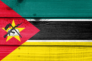 Mozambique flag painted on old wood plank background. Brushed natural light knotted wooden board texture. Wooden texture background flag of Mozambique