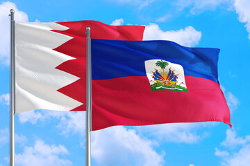 Haiti and Bahrain national flag waving in the windy deep blue sky. Diplomacy and international...