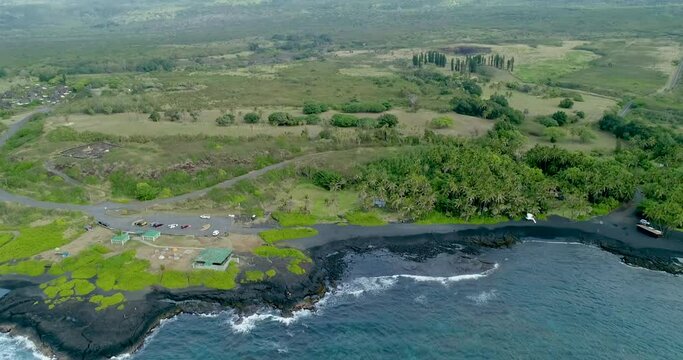 backwards tracking over water in bay aerial view of Punaluu beach,The beach has black sand made of basalt and created by lava flowing into the ocean,Big Island,Hawaii.usa