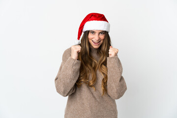 Caucasian girl with christmas hat isolated on white background celebrating a victory in winner position