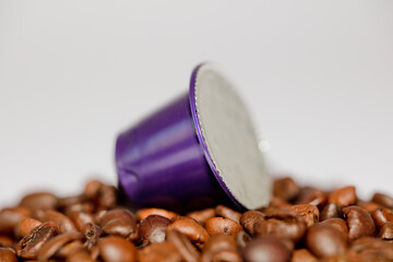 purple coffee capsule, on coffee beans, white background
