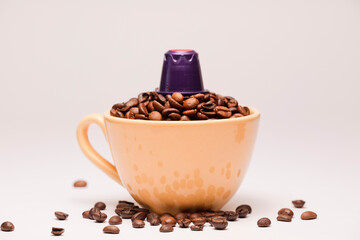 purple coffee capsule, with yellow porcelain cup, with coffee beans, white background