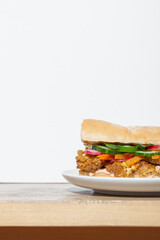 Vegan Banh Mi sandwich with roasted cauliflower and pickled vegetables on white plate. Copy space
