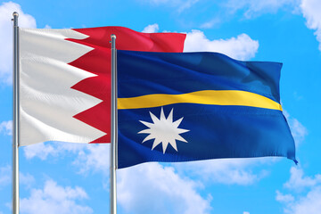 Nauru and Bahrain national flag waving in the windy deep blue sky. Diplomacy and international relations concept.