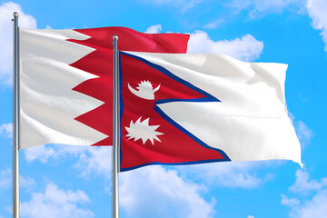 Nepal and Bahrain national flag waving in the windy deep blue sky. Diplomacy and international relations concept.