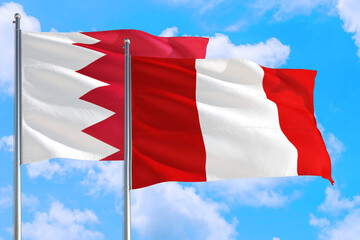 Peru and Bahrain national flag waving in the windy deep blue sky. Diplomacy and international relations concept.
