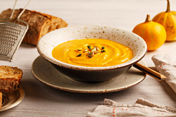 Pumpkin soup with cream, sweet potato, carrot, pumpkins seeds and thyme leaves