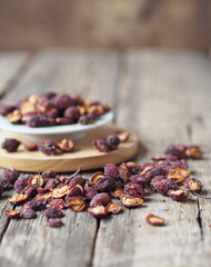 Dried hawthorn on a wooden ancient background. Home harvesting of dried fruits.