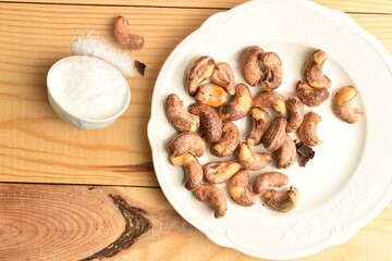 Fototapeta premium Several roasted cashews, close-up, on a wooden table.