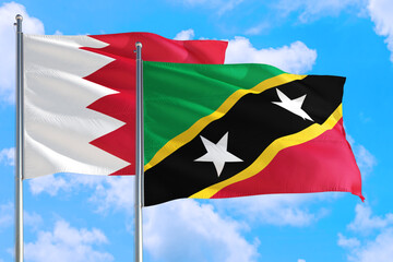 Saint Kitts And Nevis and Bahrain national flag waving in the windy deep blue sky. Diplomacy and international relations concept.