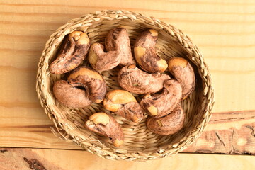 Fototapeta premium Several roasted cashews, close-up, on a wooden table.