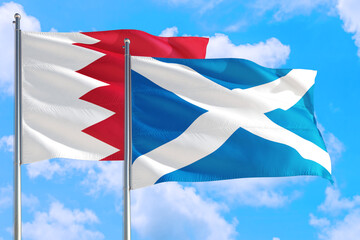 Scotland and Bahrain national flag waving in the windy deep blue sky. Diplomacy and international relations concept.