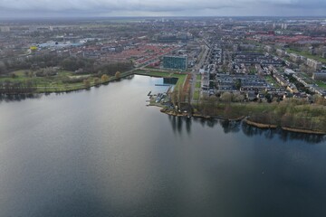 Aerial view over a city next to a lake in Europe with bare trees due to winter