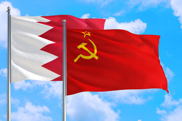 Soviet Union and Bahrain national flag waving in the windy deep blue sky. Diplomacy and international relations concept.