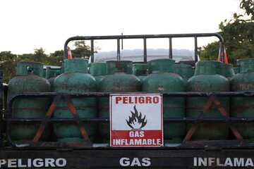 A pick-up truck loaded with gas bottles and a sign saying 