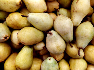 Pears. Lots of yellow pears in the supermarket. Storage of pears. Selling pears. View from above. Healthy snacks. Texture. Background. Fruit.