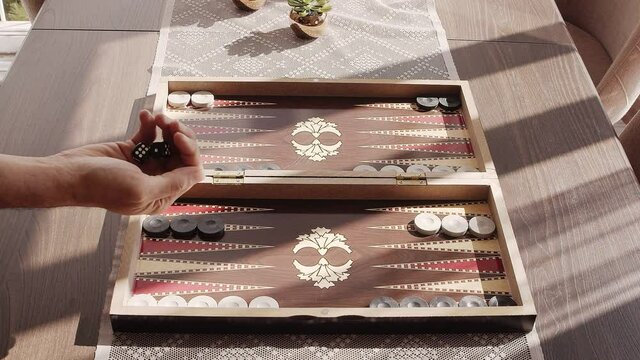 Backgammon is a video that exhibits footage of the traditional Turkish backgammon game board. Hand throws dice in slow motion. You can use this 1920x1080 (HD) bit of video in any project.