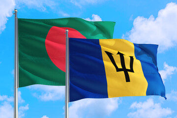 Barbados and Bangladesh national flag waving in the windy deep blue sky. Diplomacy and international relations concept.