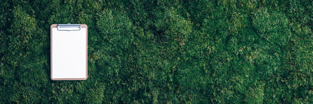 Clipboard, Paper, Pen On Green Grass, Moss Background. Copy Space. Top View. Office Mock Up, Remote Job. Wild Nature, Ecology Concept. Summer Forest. Sustainable, Organic, Zero Waste Lifestyle