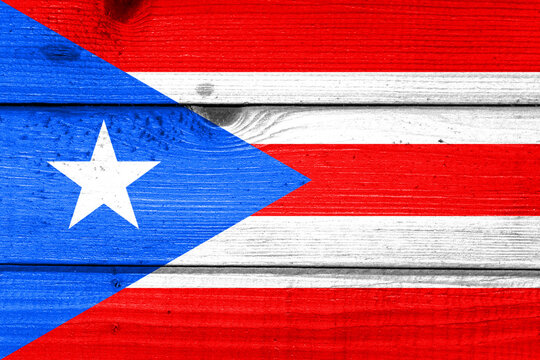 Puerto Rico flag painted on old wood plank background. Brushed natural light knotted wooden board texture. Wooden texture background flag of Puerto Rico.