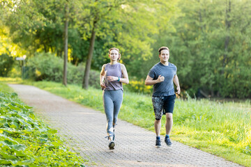 Young couple running in a forest and making fitness workout