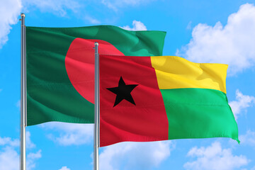 Guinea and Bangladesh national flag waving in the windy deep blue sky. Diplomacy and international relations concept.