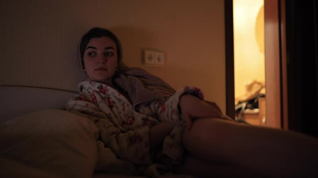 Woman watch film at the home lying on bed
