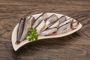 Anchovies in the bowl served basil leaves