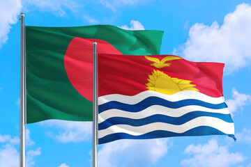 Kiribati and Bangladesh national flag waving in the windy deep blue sky. Diplomacy and international relations concept.