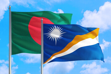 Marshall Islands and Bangladesh national flag waving in the windy deep blue sky. Diplomacy and international relations concept.