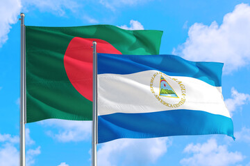 Nicaragua and Bangladesh national flag waving in the windy deep blue sky. Diplomacy and international relations concept.