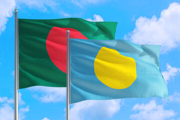 Palau and Bangladesh national flag waving in the windy deep blue sky. Diplomacy and international relations concept.