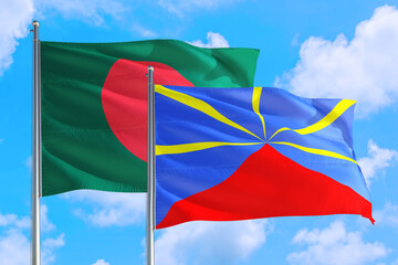 Reunion and Bangladesh national flag waving in the windy deep blue sky. Diplomacy and international relations concept.