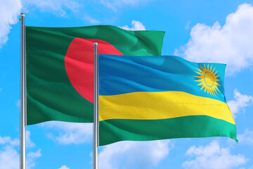 Rwanda and Bangladesh national flag waving in the windy deep blue sky. Diplomacy and international relations concept.