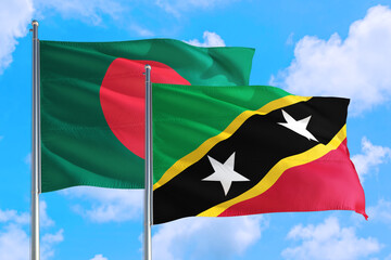 Saint Kitts And Nevis and Bangladesh national flag waving in the windy deep blue sky. Diplomacy and international relations concept.