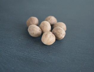 Nutmeg ,  muscat nut, Myristica fragrans nut, culinary spice on grey stone background