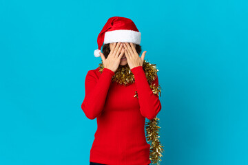 English girl with christmas hat isolated on blue background with tired and sick expression