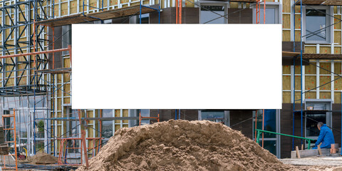 white billboard against building and ground heap at sunlight