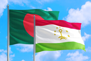 Tajikistan and Bangladesh national flag waving in the windy deep blue sky. Diplomacy and international relations concept.