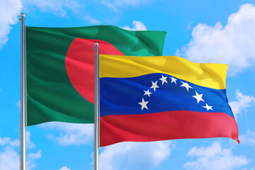 Venezuela and Bangladesh national flag waving in the windy deep blue sky. Diplomacy and international relations concept.