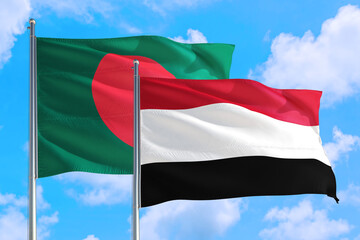 Yemen and Bangladesh national flag waving in the windy deep blue sky. Diplomacy and international relations concept.