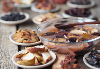 Fruit jelly with dried fruits surrounded by dried fruits on plates on a wooden background. Healthy natural homemade dessert.Home preparation of dried fruits.