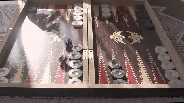 Backgammon is a video that exhibits footage of the traditional Turkish backgammon game board. Hand throws dice in slow motion. You can use this 1920x1080 (HD) bit of video in any project.