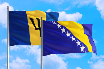Bosnia Herzegovina and Barbados national flag waving in the windy deep blue sky. Diplomacy and international relations concept.