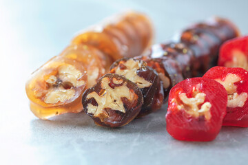 Caucasian delicacy churchkhela with grapes and walnuts on grey background. Traditional eastern cuisine. Traditional middle eastern sweets. Jewish, turkish, arabic national dessert. Turkish delight