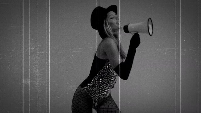Young woman wearing black top hat and fishnets using megaphone