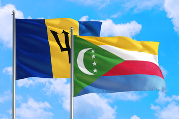 Comoros and Barbados national flag waving in the windy deep blue sky. Diplomacy and international relations concept.